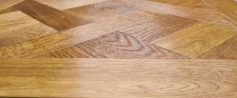 Eine Nahaufnahme eines Holzbodens mit einem Muster darauf.