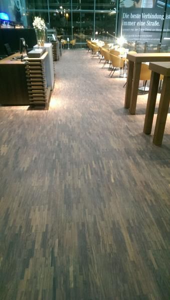 Ein Holzboden in einem Raum mit Tischen und Stühlen