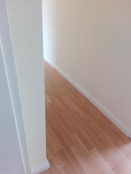 Ein Flur mit Holzboden und weißen Wänden.
