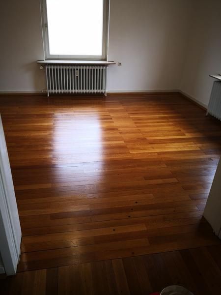 Ein leerer Raum mit Holzboden und Fenster.