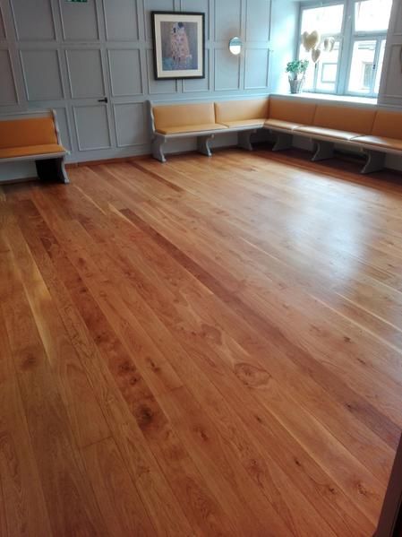 Ein großer Raum mit Holzboden und Bänken