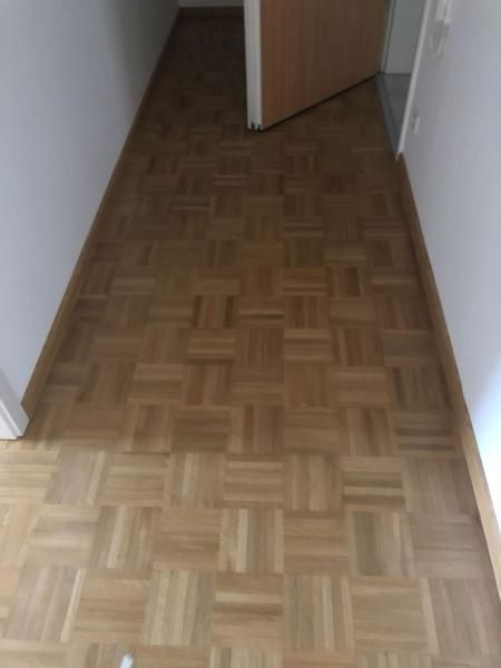 Ein Flur mit Parkett und einer Tür