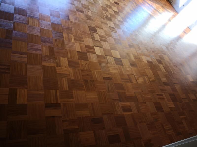 Ein Holzboden mit einem Muster aus Quadraten darauf