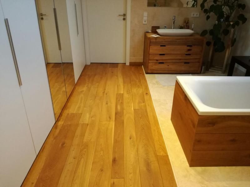 Ein Badezimmer mit Holzboden und Badewanne