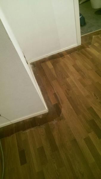 Ein Holzboden in einem Raum neben einer Tür.