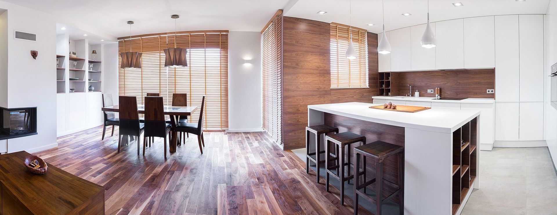 Eine Küche und ein Esszimmer mit Holzböden und weißen Schränken.