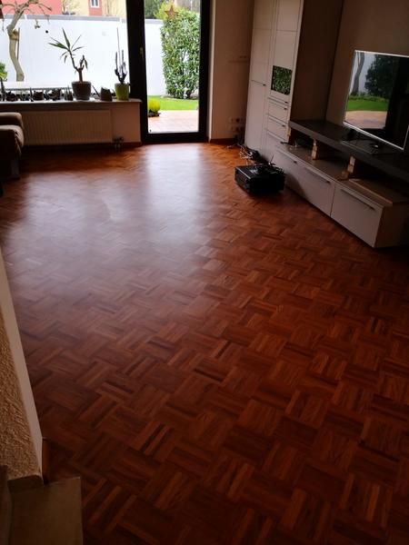 Ein Wohnzimmer mit Holzboden und Fernseher