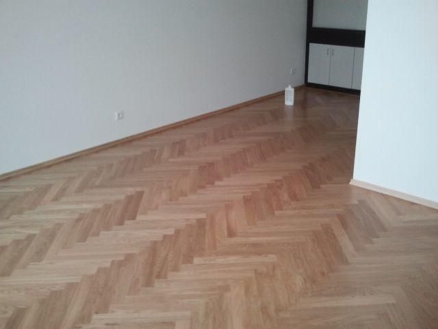Ein leerer Raum mit einem Fischgrätholzboden