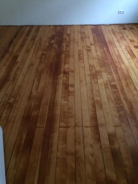 Ein Holzboden in einem Raum mit einer weißen Wand.