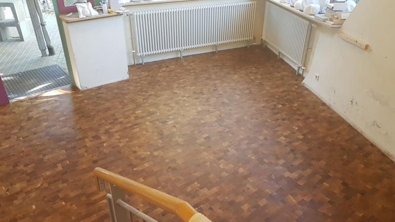 Ein Raum mit Holzboden und Heizkörper.