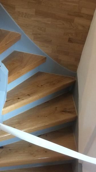 Eine Wendeltreppe mit Holzstufen und einem weißen Geländer