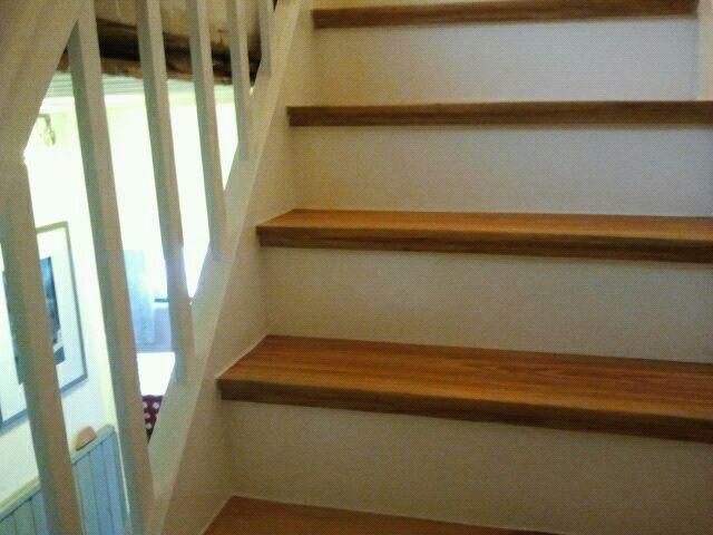 Eine Treppe mit Holzstufen und einem weißen Geländer