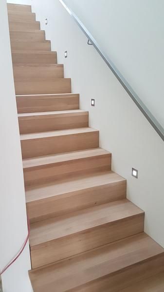 Eine Holztreppe mit einem Metallgeländer in einem Haus.