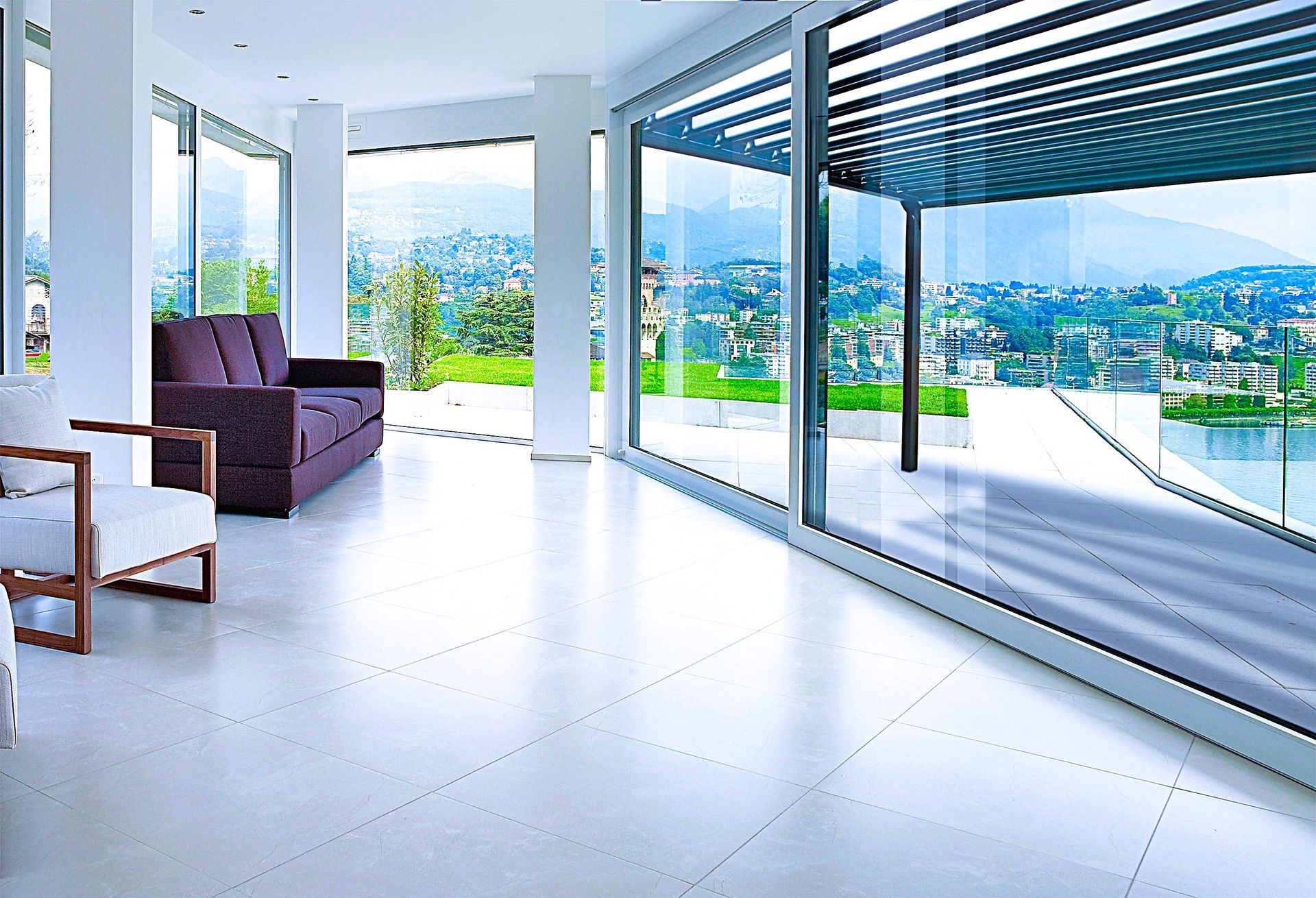 Patio moderne ouvert avec sol blanc, chaise longue et vue panoramique sur la ville et les montagnes