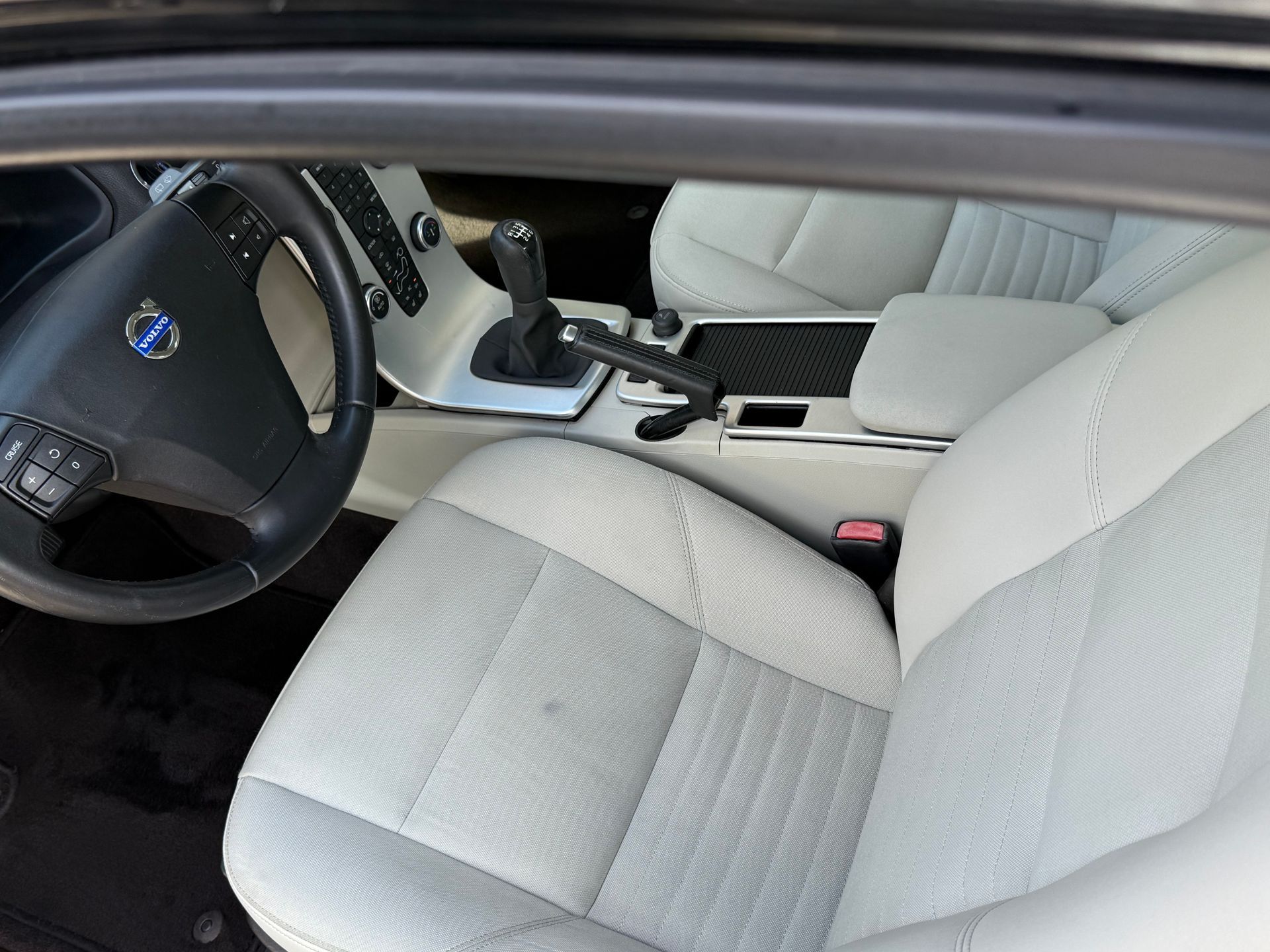 Interior de un automóvil Volvo con asientos, volante y consola de cuero gris claro.