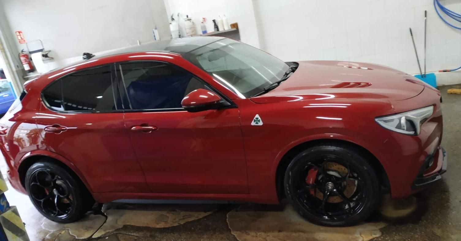 Todoterreno Alfa Romeo Stelvio de color rojo en un lavadero de vehículos.