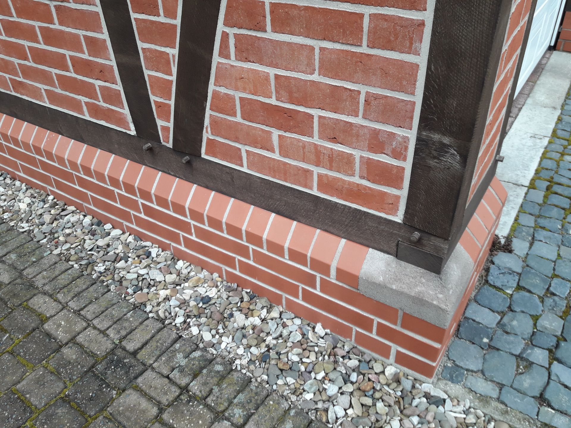 Nahaufnahme einer Gebäudeecke aus Backstein mit roten Ziegeln.