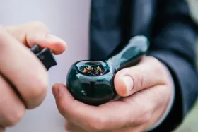 Una persona sostiene una pipa en sus manos.