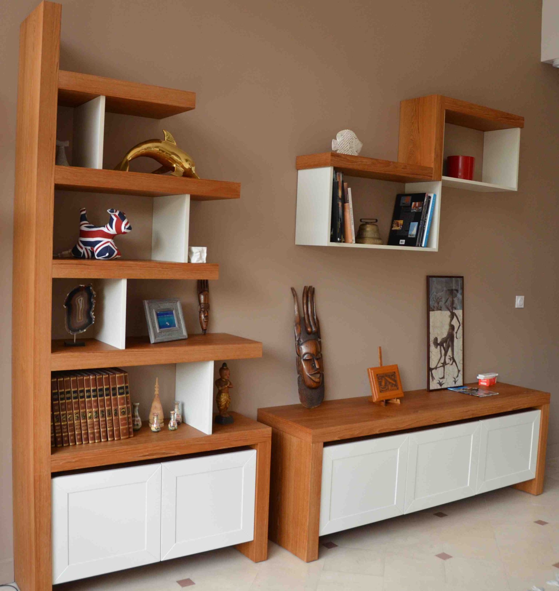 Étagères et armoire en bois contre un mur beige, contenant divers objets décoratifs.