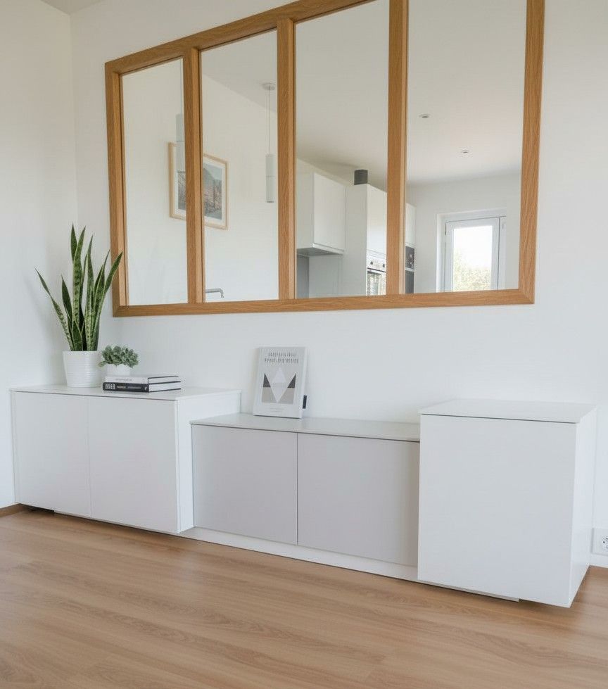 Armoires flottantes blanches sous une fenêtre à cadre en bois dans une pièce avec parquet.