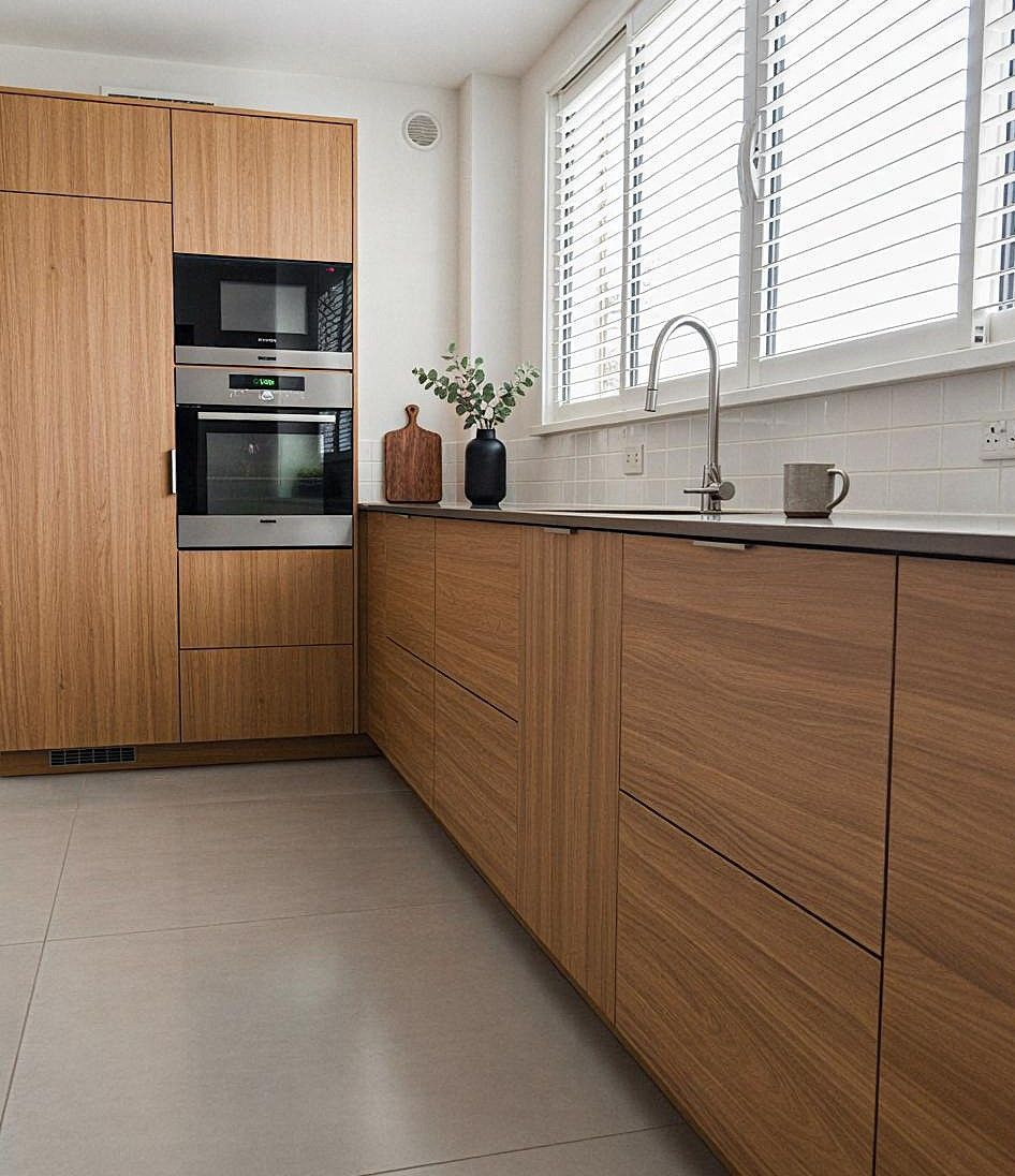 Tiroirs d'armoires de cuisine blancs avec poignées argentées, comptoir en bois.