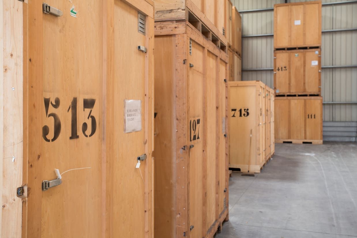 Unités de stockage en bois avec numéros noirs dans un entrepôt.