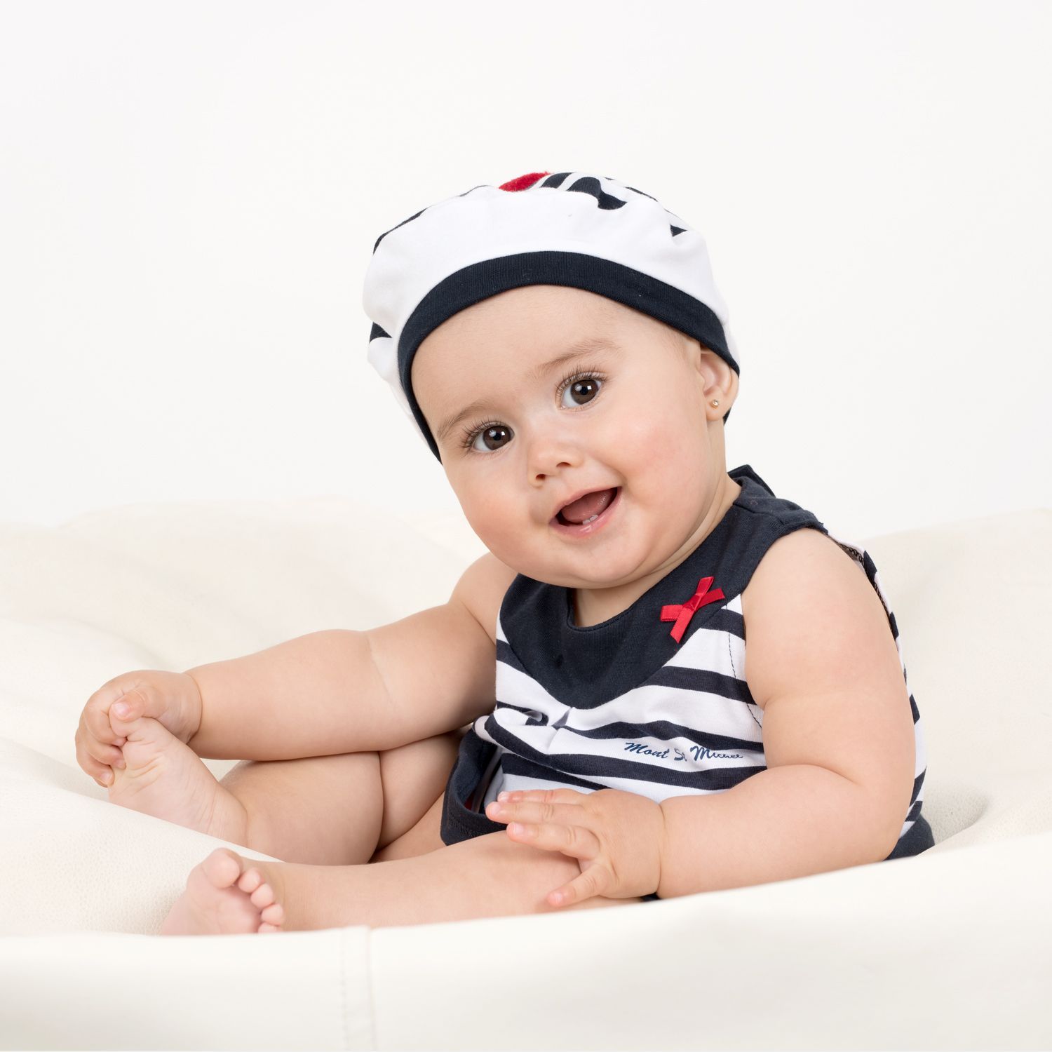 Un bébé souriant en tenue de marin.