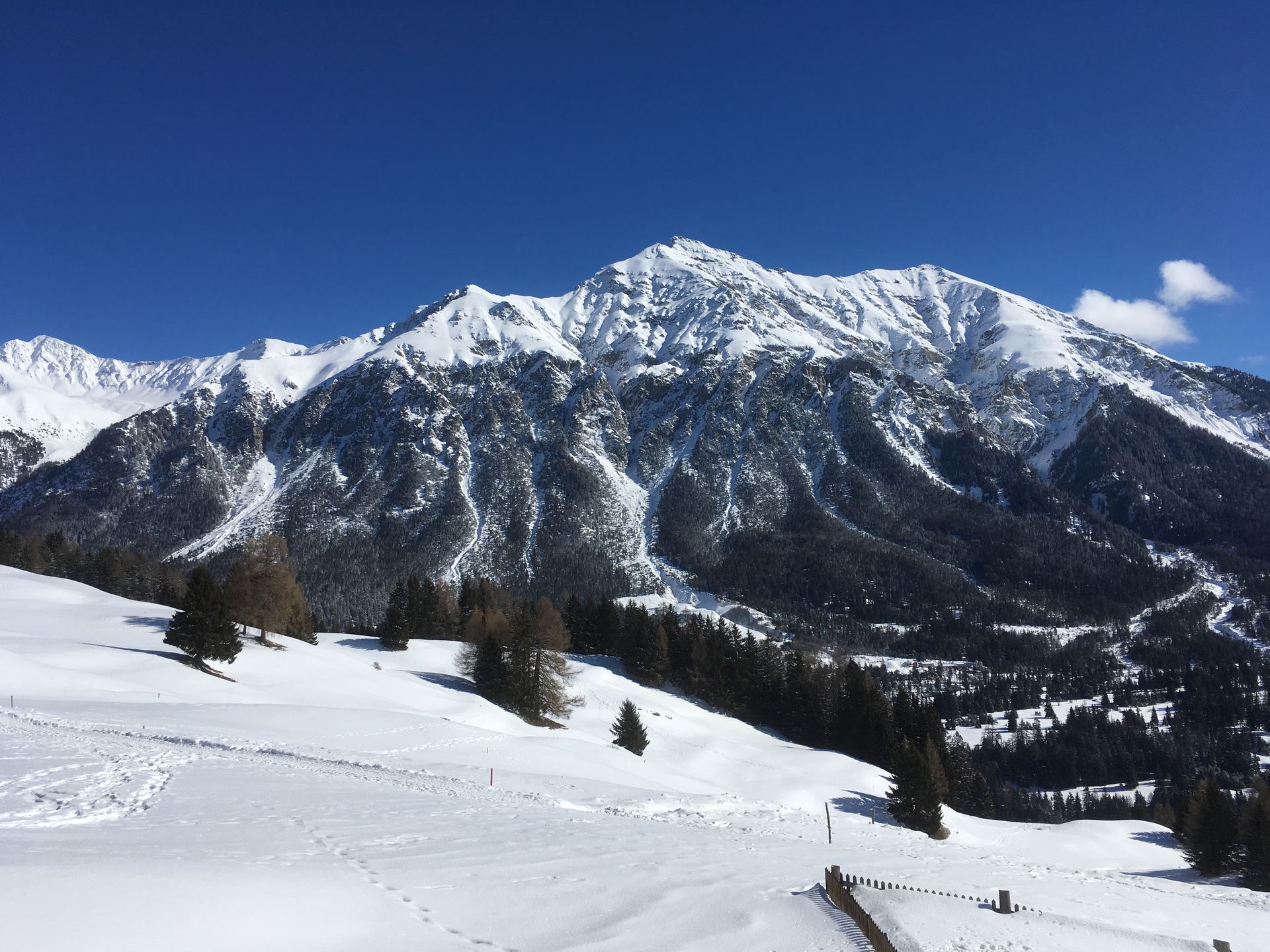 Ein Mann steht auf einem Berggipfel.