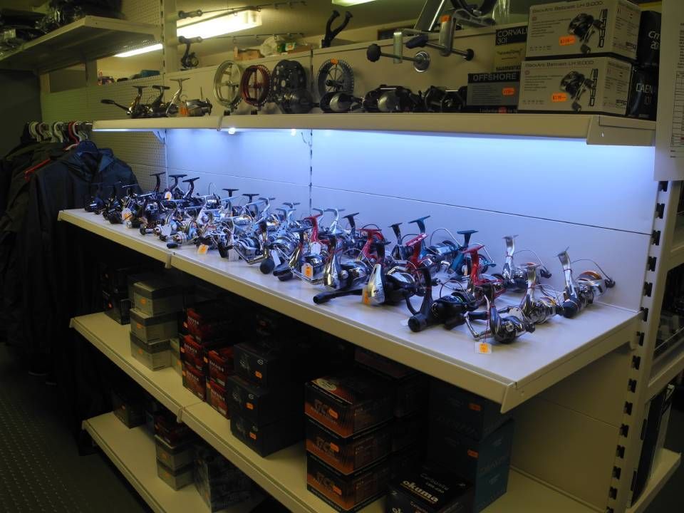 Ein Regal voller Stationärrollen im Geschäft von Hufschmid Fischereibedarf