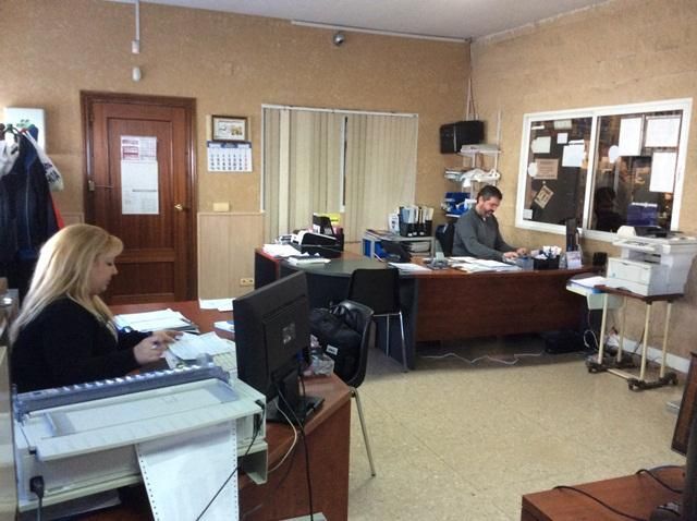 Un hombre y una mujer están sentados en escritorios en una oficina.