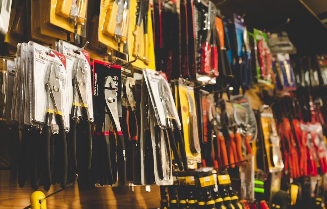 Un montón de herramientas colgadas en la pared de una tienda.