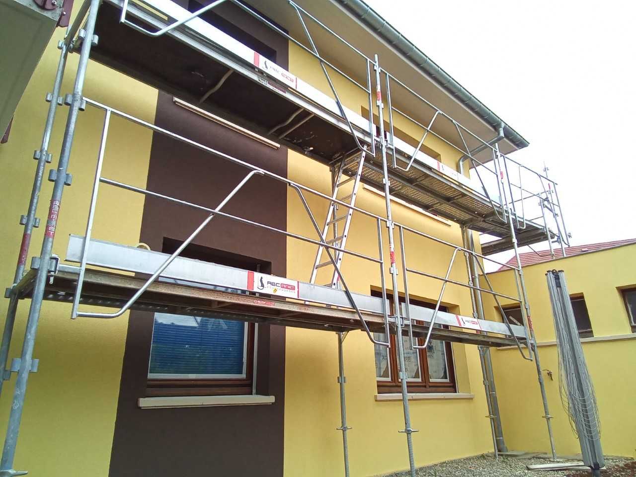 Échafaudage devant maison jaune et marron