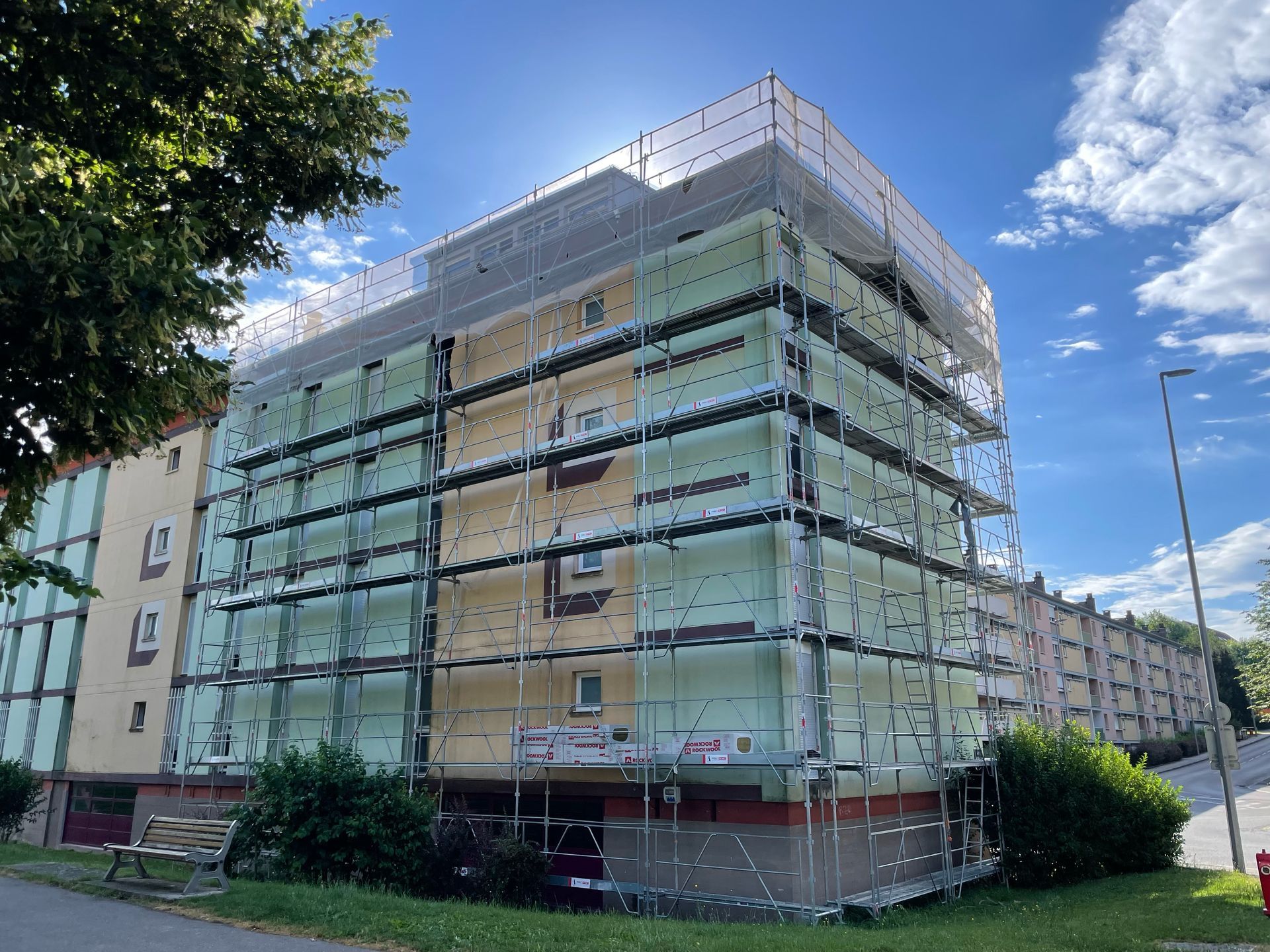échafaudage sur grand immeuble vert et jaune