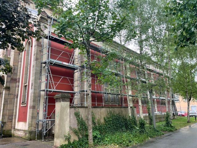 échafaudage devant bâtiment rouge