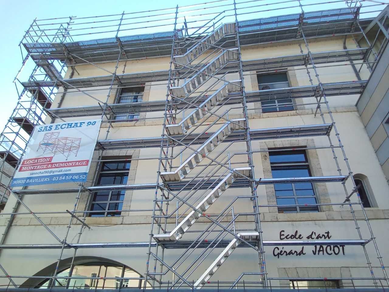 Vue du dessous d'un échafaudage à escalier devant immeuble