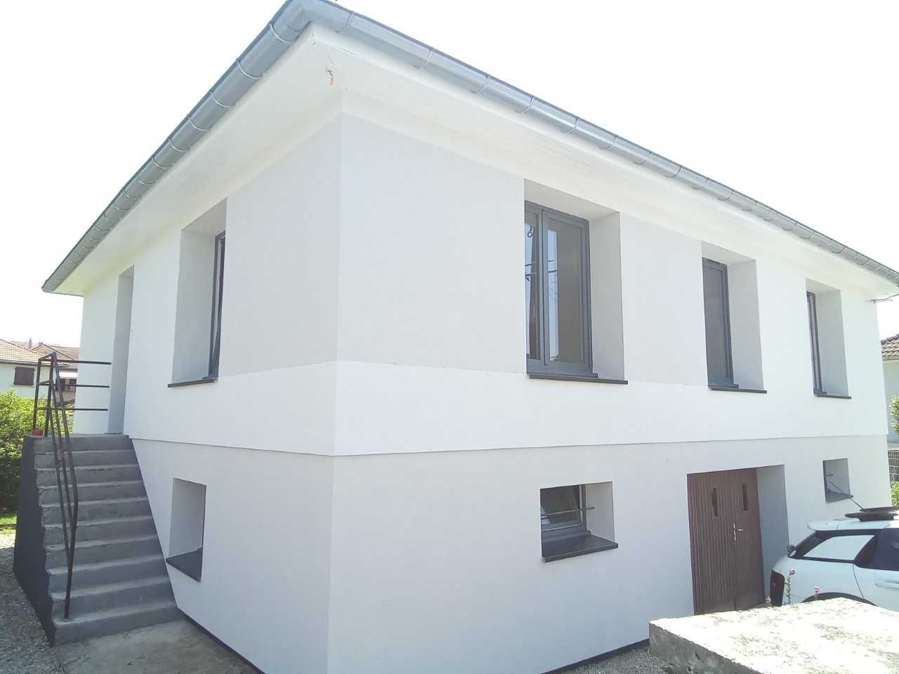 Façade lisse d'un immeuble avec fenêtre en PVC noir