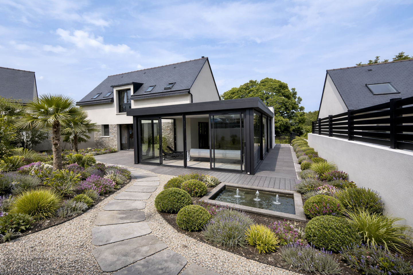 Jardin moderne avec véranda vitrée, allée en pierre, jardin de gravier et petit étang