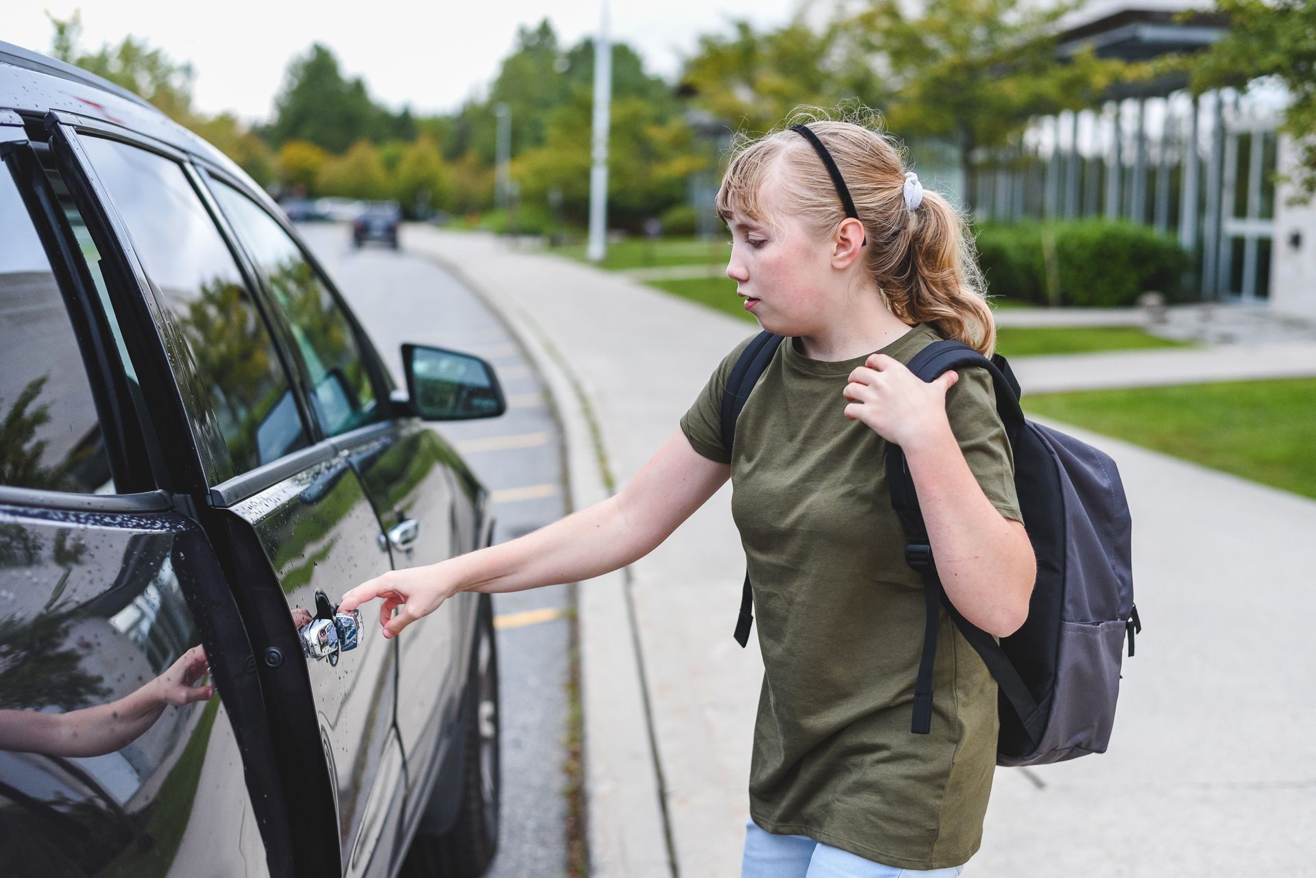 Une écolière ouvre la porte d’un taxi scolaire
