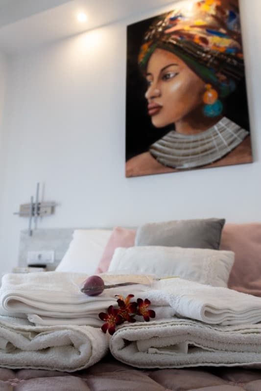 Un dormitorio con un cuadro de una mujer en la pared encima de la cama.