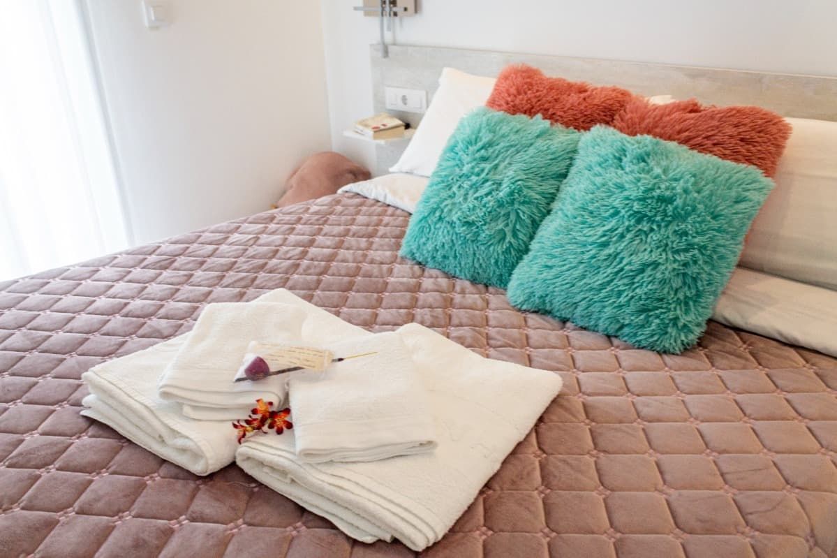 Una sala de estar con sofá, silla, mesa de café y televisión.