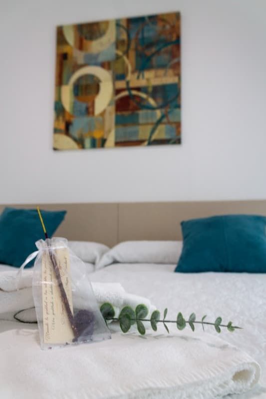 Una cama con un cuadro en la pared encima.