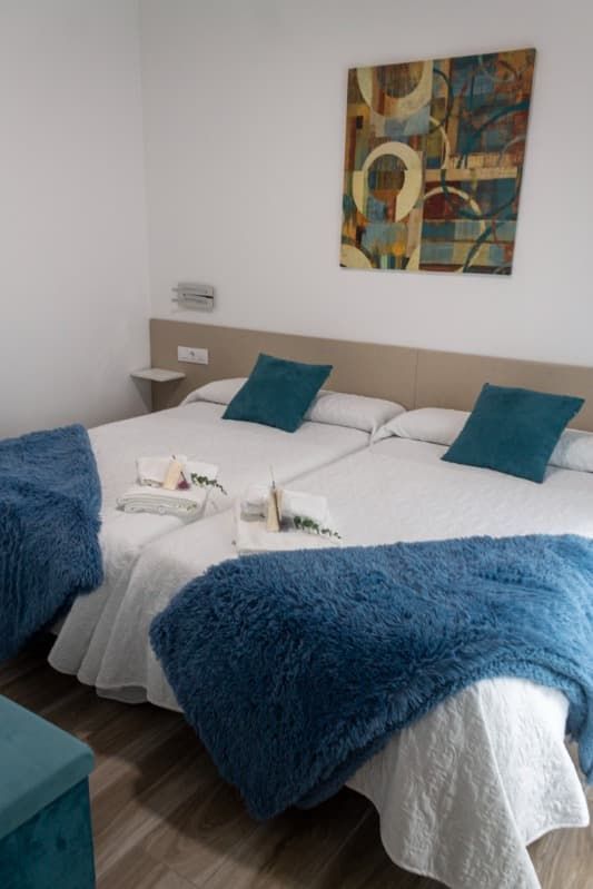 Un dormitorio con cama, armario, televisión y puertas corredizas de cristal.