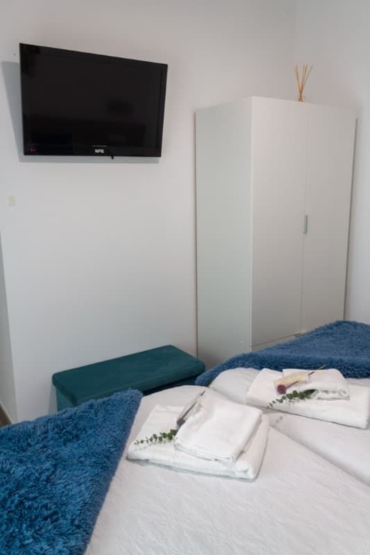 Un dormitorio con dos camas y un televisor de pantalla plana.