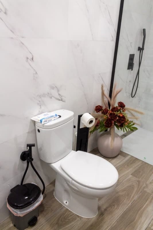 Un baño con lavabo, espejo y suelo de madera.