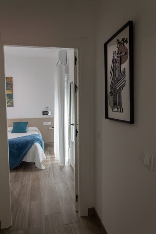 Un dormitorio con una cama y un cuadro en la pared.
