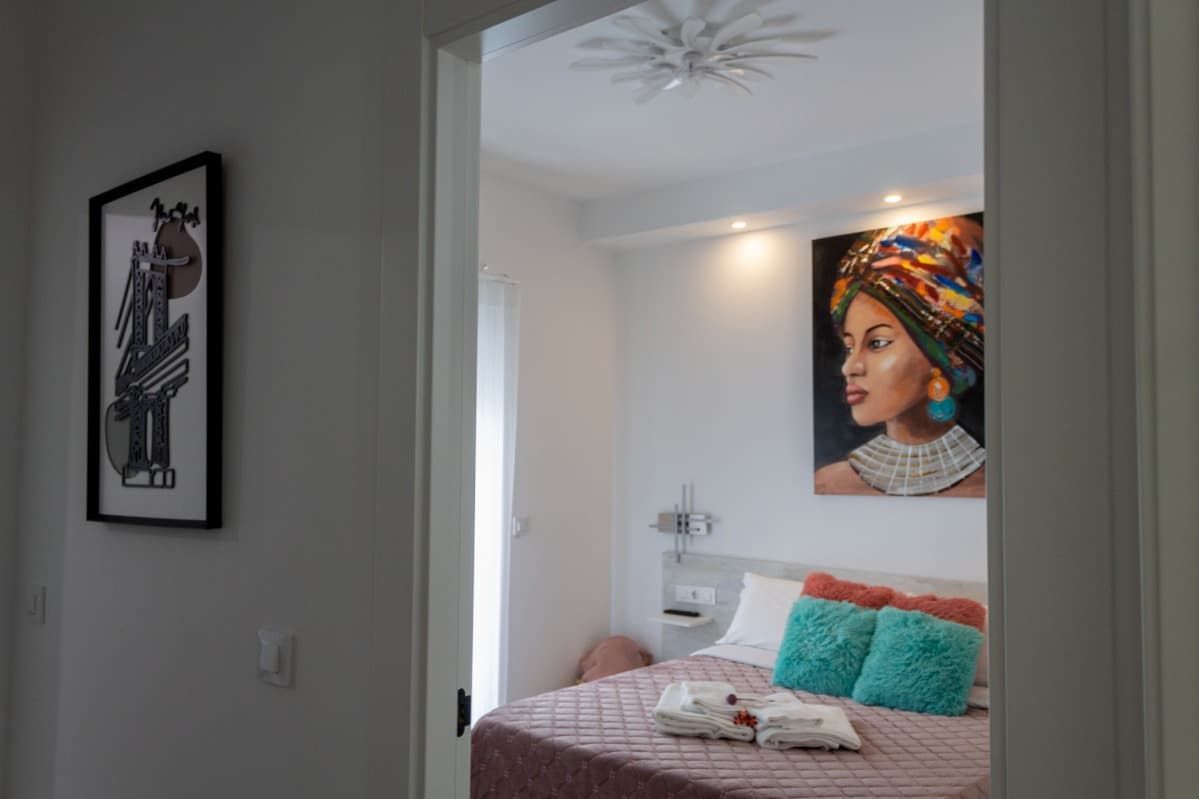 Un dormitorio con dos camas y un televisor de pantalla plana en la pared.