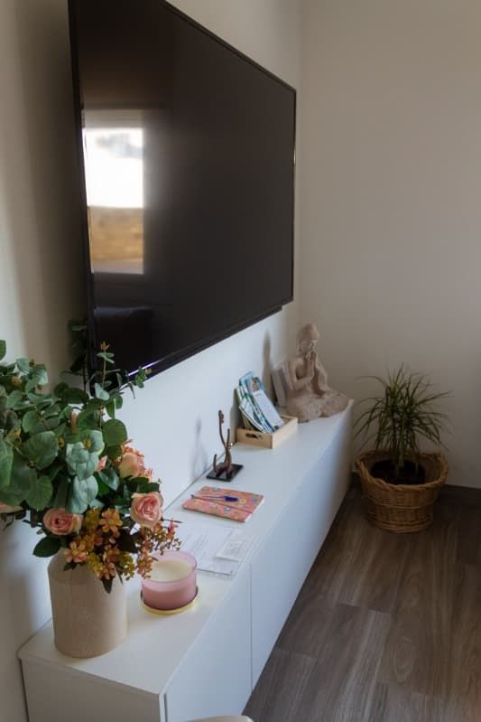 Una sala de estar con un televisor de pantalla plana colgado en la pared.