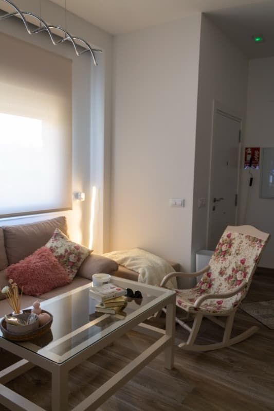 Una sala de estar con un sofá y una mecedora.