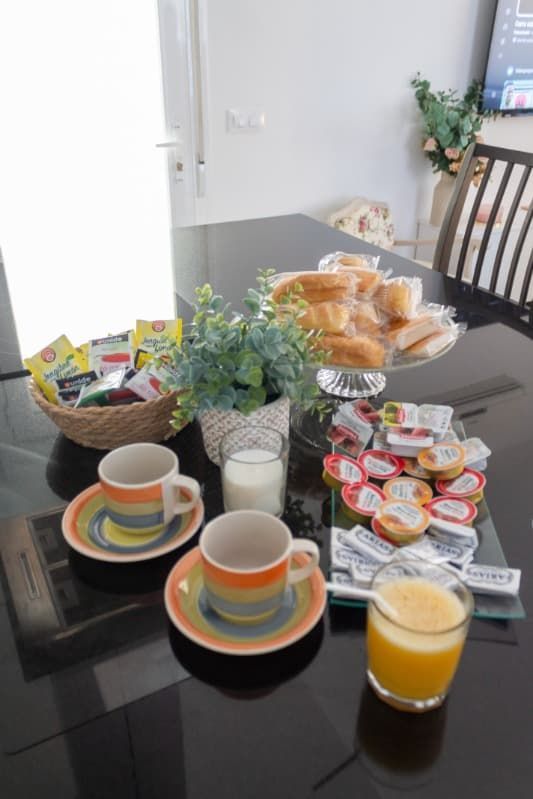 Una mesa con dos tazas de café y un vaso de jugo de naranja.