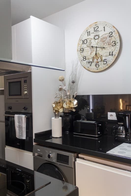 Una cocina con un reloj en la pared y un reloj en el mostrador.